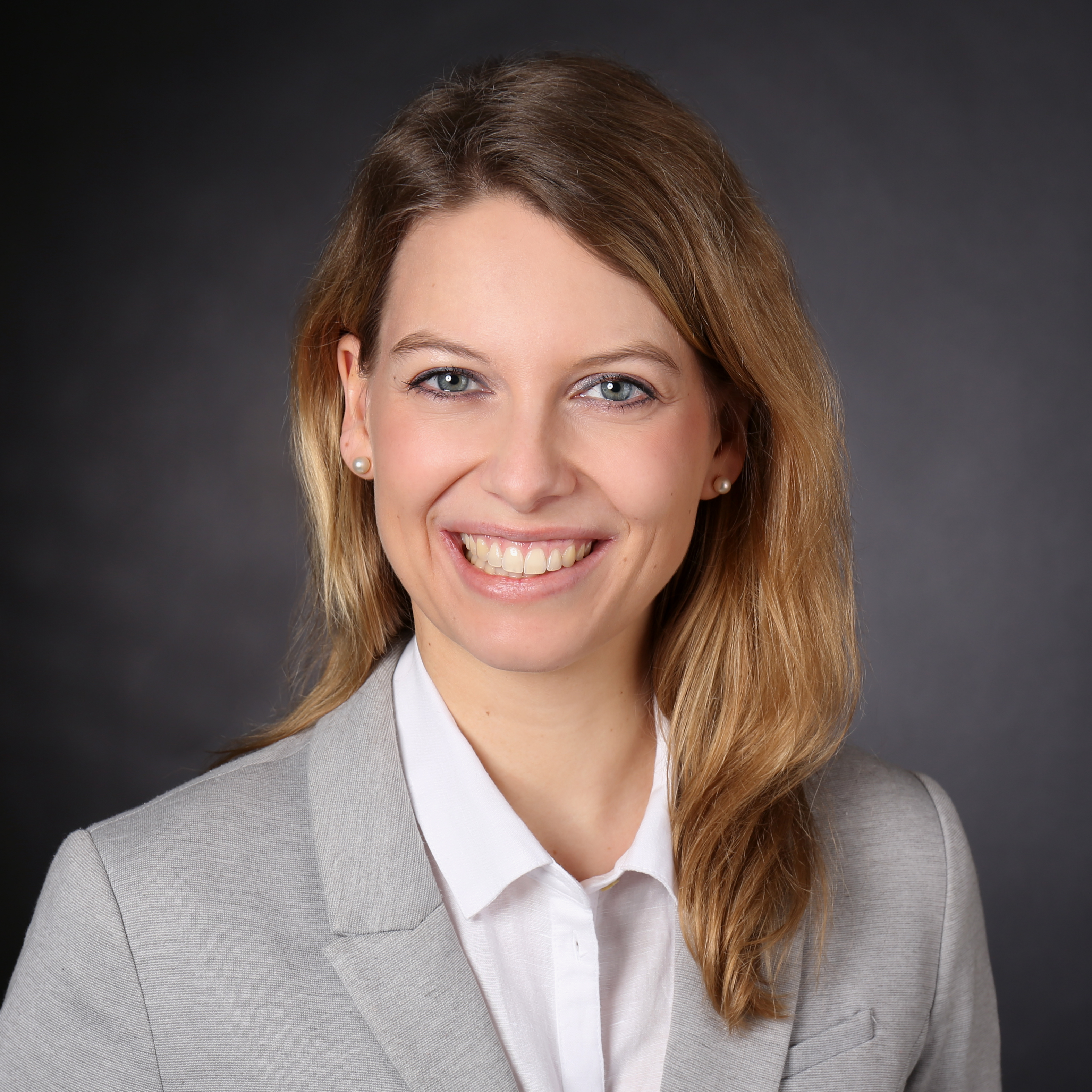 Portrait photo of a friendly smiling young woman with medium-length blonde hair