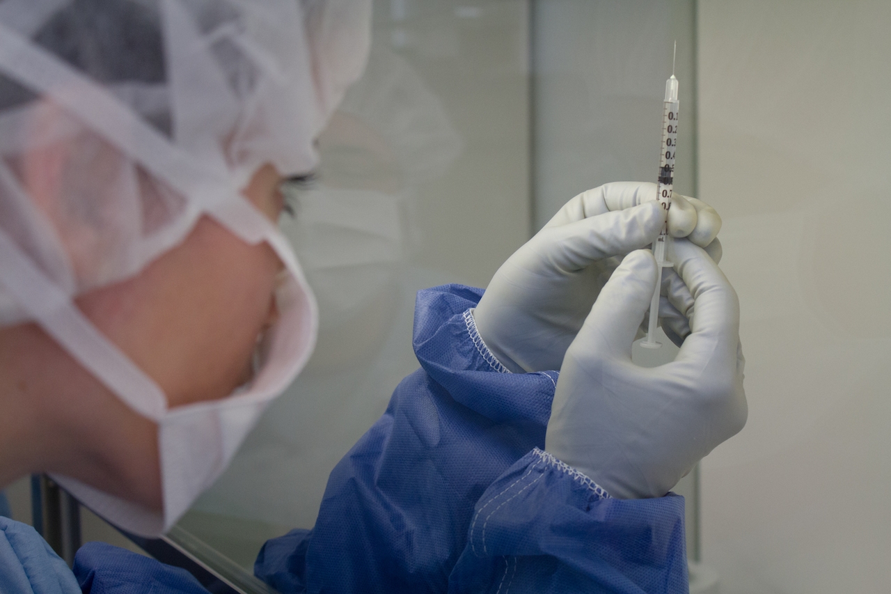 Woman holding a syringe with vaccine.