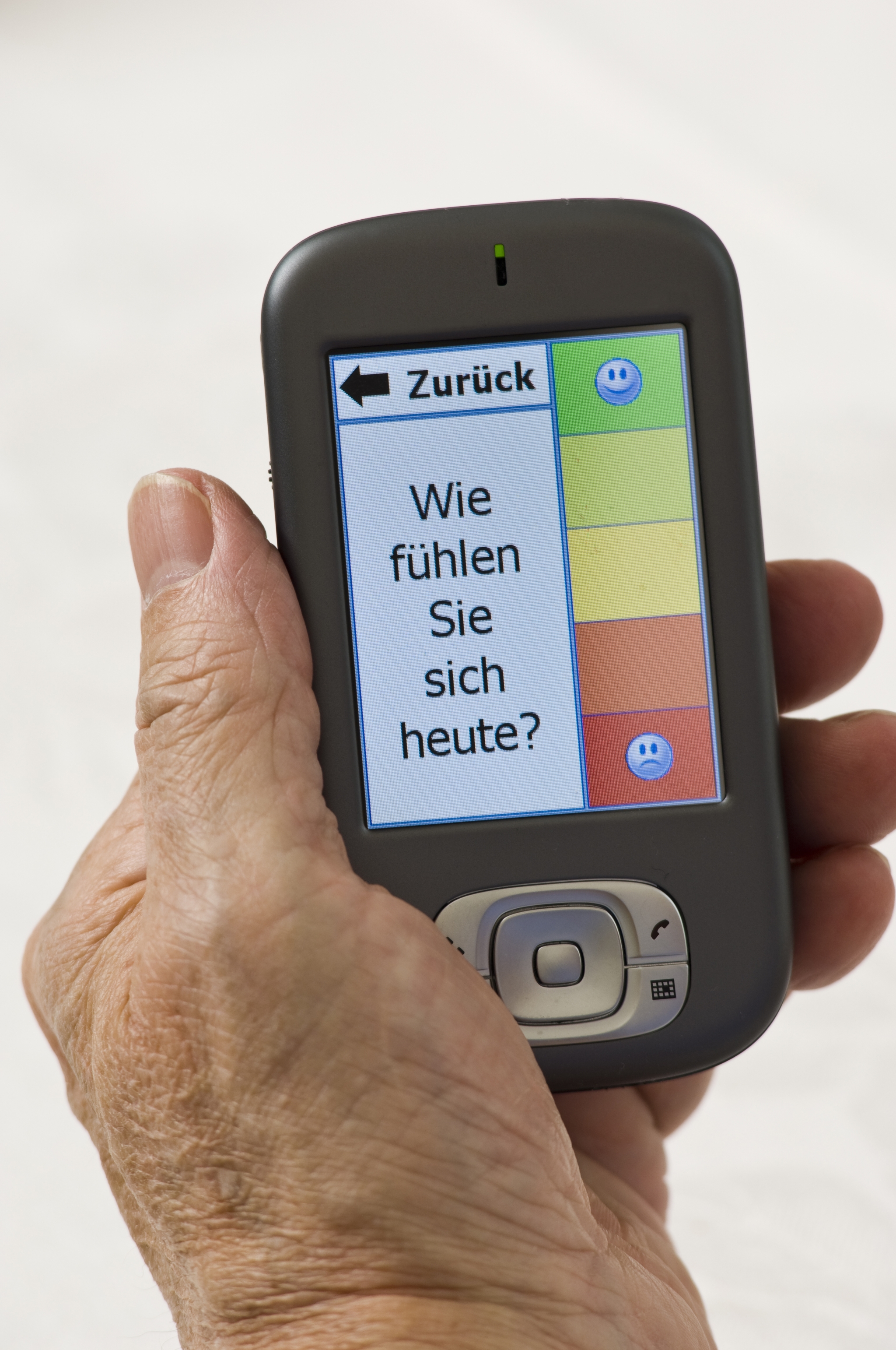 Patient gibt sein Befinden in ein Handy ein.